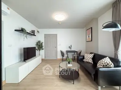 Modern living room with sleek black sofa, stylish decor, and natural light