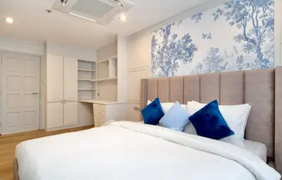 Elegant bedroom with stylish wallpaper and cozy bedding in modern apartment.