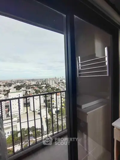Stunning city view from high-rise balcony with sleek glass railing.