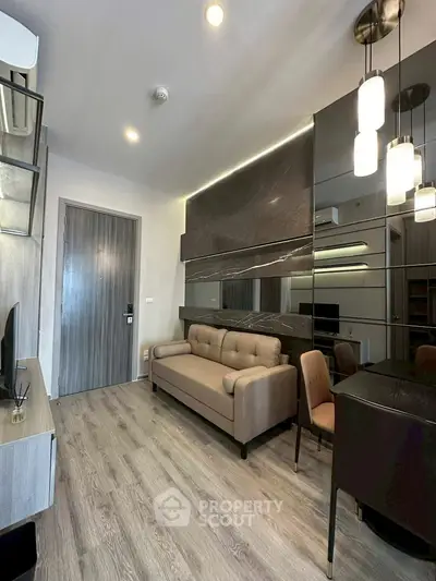 Modern living room with sleek design, featuring a cozy sofa and stylish lighting fixtures.