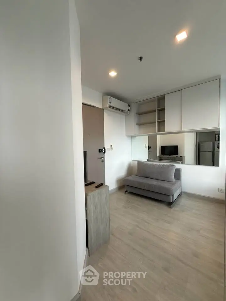 Modern living room with sleek design and neutral tones, featuring a cozy sofa and built-in storage.