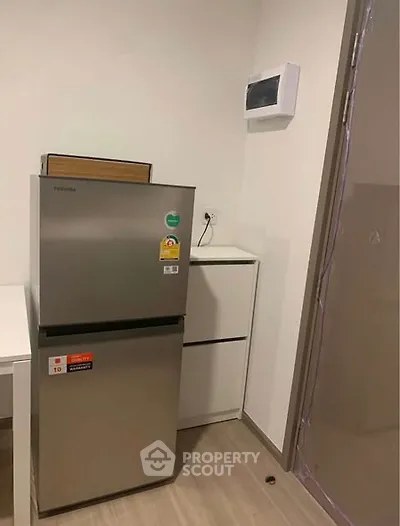 Modern kitchen corner with sleek fridge and minimalist design.