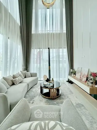 Luxurious high-ceiling living room with elegant decor and large windows