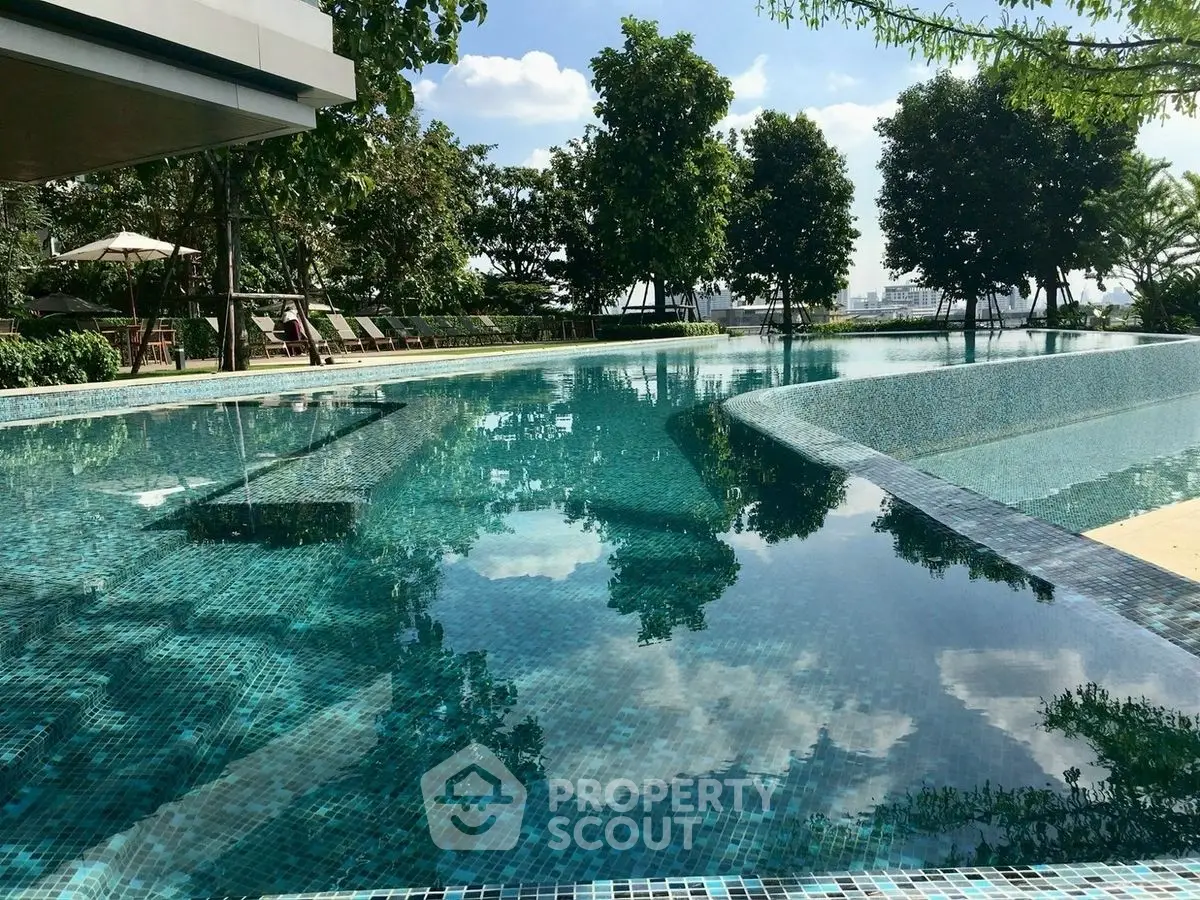 Luxurious outdoor pool with serene surroundings and lush greenery, perfect for relaxation and leisure.