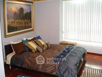 Cozy bedroom with elegant decor and large window for natural light.