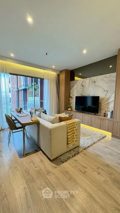 Spacious modern living room with elegant decor and large TV, featuring floor-to-ceiling windows and stylish furniture.