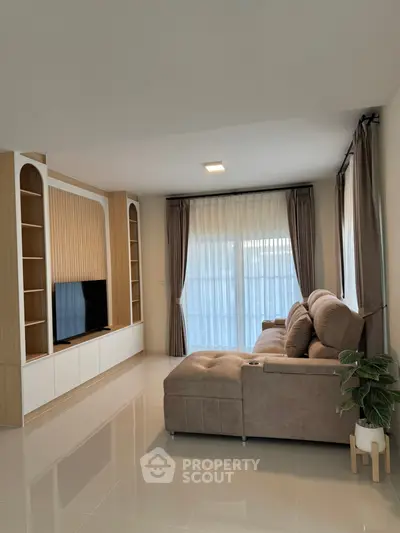 Modern living room with sleek design, large sofa, and built-in TV unit.