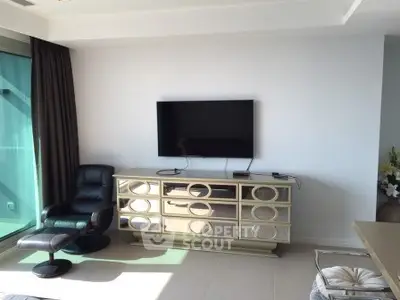 Modern living room with sleek TV setup and stylish furniture in a bright apartment.