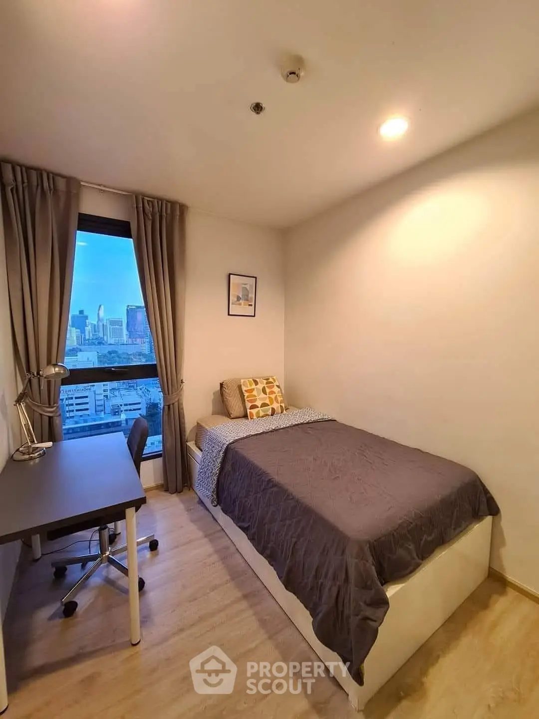 Cozy bedroom with city view, modern decor, and natural light.