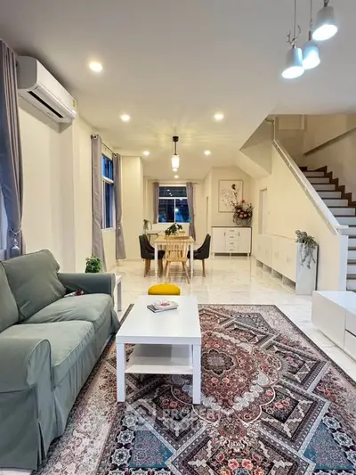 Spacious living room with elegant decor and modern lighting, perfect for family gatherings.