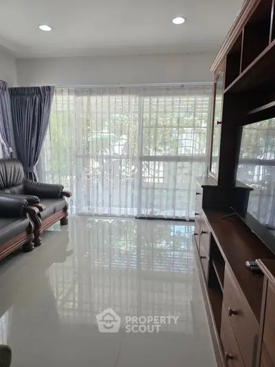Spacious living room with elegant furniture and large windows offering natural light.