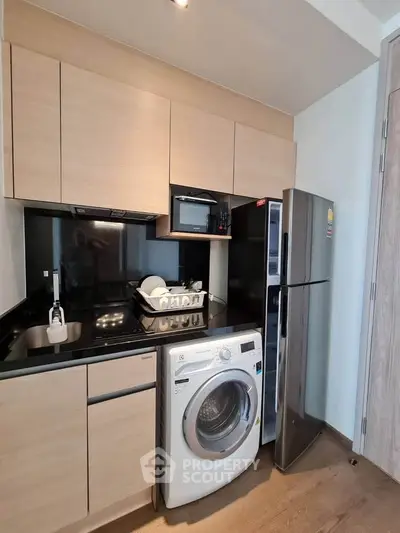 Modern compact kitchen with washing machine and stainless steel fridge