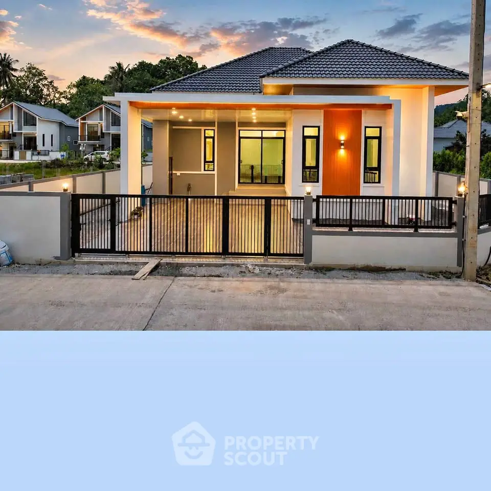 Modern single-story house with sleek design and spacious driveway at sunset.