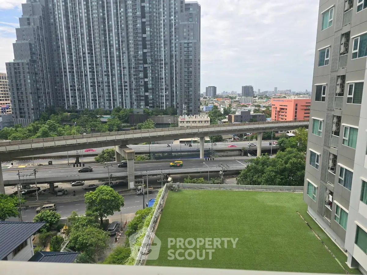 Stunning urban view from high-rise balcony overlooking cityscape and highway.