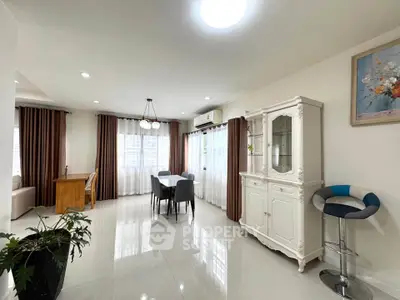 Spacious living room with elegant decor and natural light, featuring a dining area and stylish furniture.