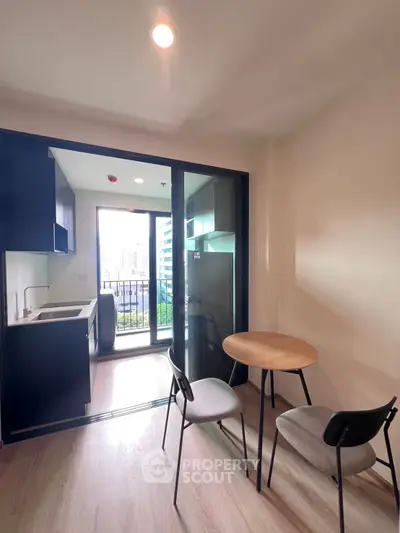 Modern compact kitchen with dining area and balcony view