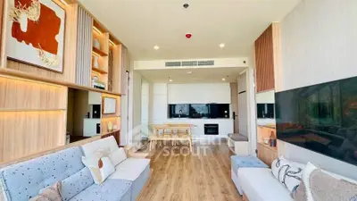 Modern living room with open kitchen, stylish decor, and ample natural light in a contemporary apartment.