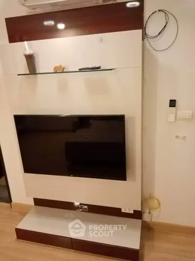 Modern living room with sleek TV unit and wooden flooring, showcasing contemporary interior design.