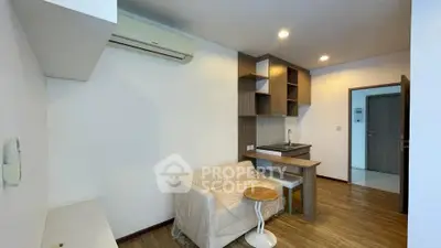 Modern compact living room with kitchenette and air conditioning in cozy apartment.