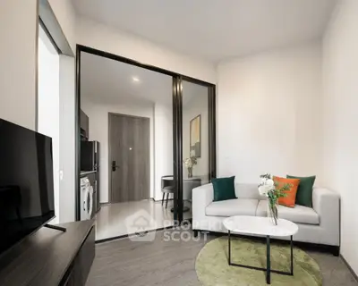 Modern living room with stylish decor and open layout, featuring a cozy sofa and sleek TV setup.
