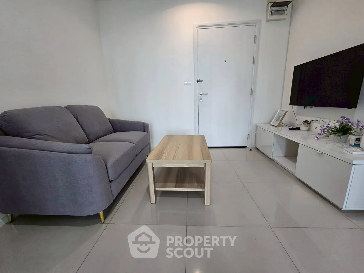 Modern living room with sleek furniture and wall-mounted TV