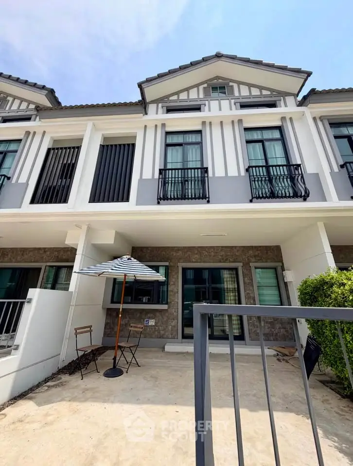 Charming modern townhouse with stylish facade and cozy outdoor patio area.