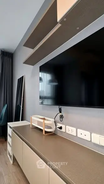 Modern living room with wall-mounted TV and sleek storage unit