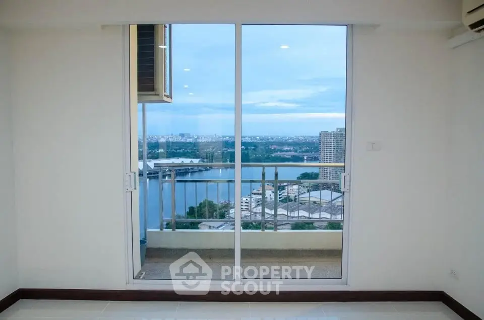 Spacious apartment with stunning balcony view overlooking the city skyline and river.