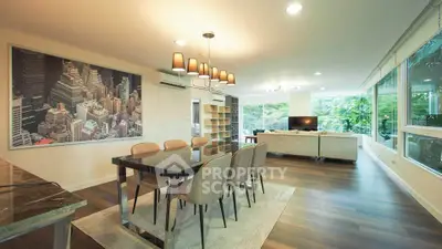 Spacious modern living room with elegant dining area and large windows offering lush garden views.