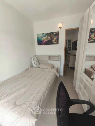 Cozy bedroom with single bed, modern decor, and wall art in a bright apartment.