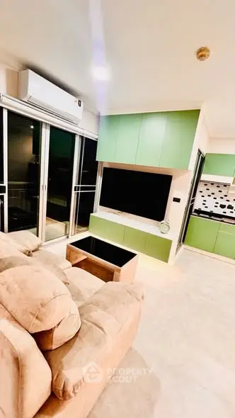 Modern living room with green cabinetry and cozy beige sofa, featuring open layout and sleek design.