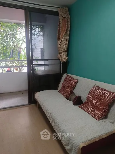 Cozy living room with teal accent wall and balcony access