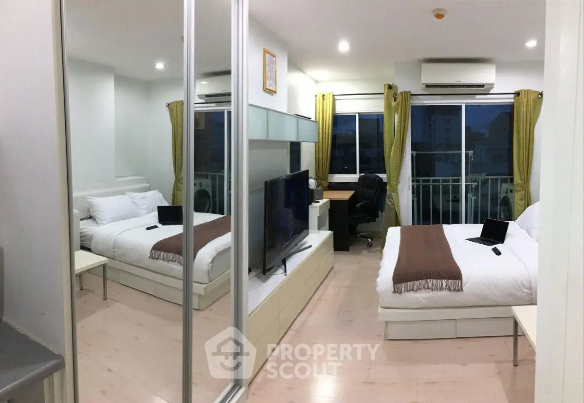 Modern bedroom with mirrored closet, twin beds, and balcony view in stylish apartment.
