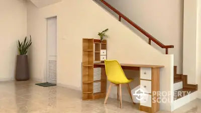 Stylish home office under staircase with modern desk and vibrant yellow chair