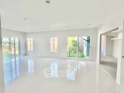 Spacious and bright living room with large windows and garden view