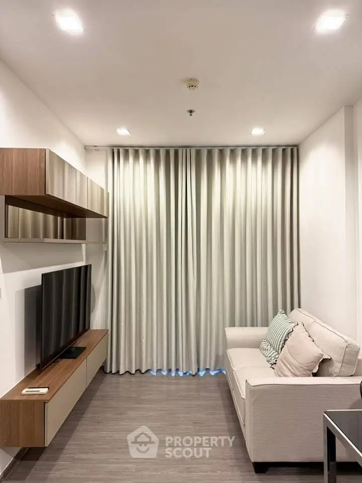 Modern living room with sleek furniture and large TV, perfect for relaxation and entertainment.