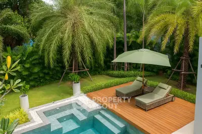 Luxurious backyard with pool and sun loungers surrounded by lush greenery, perfect for relaxation.