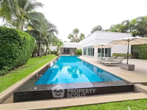 Luxurious modern villa with a stunning private pool and lush garden, perfect for relaxation and entertainment.