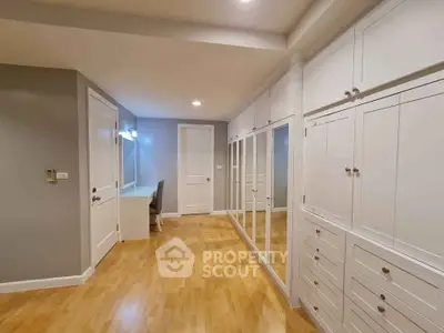 Spacious modern storage room with mirrored cabinets and wooden flooring