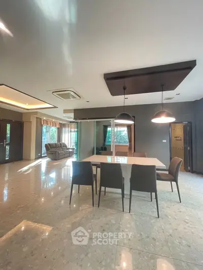 Spacious modern living room with elegant dining area and large windows