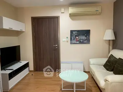 Cozy living room with modern furniture and air conditioning, perfect for relaxation.