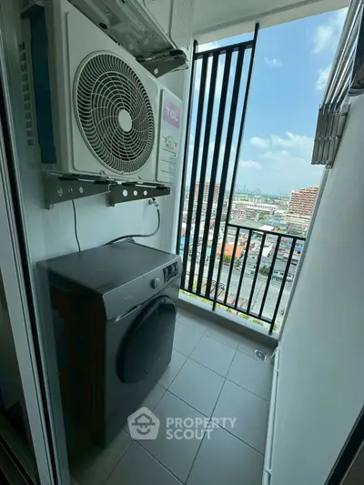 Compact balcony with washing machine and city view, ideal for urban living.