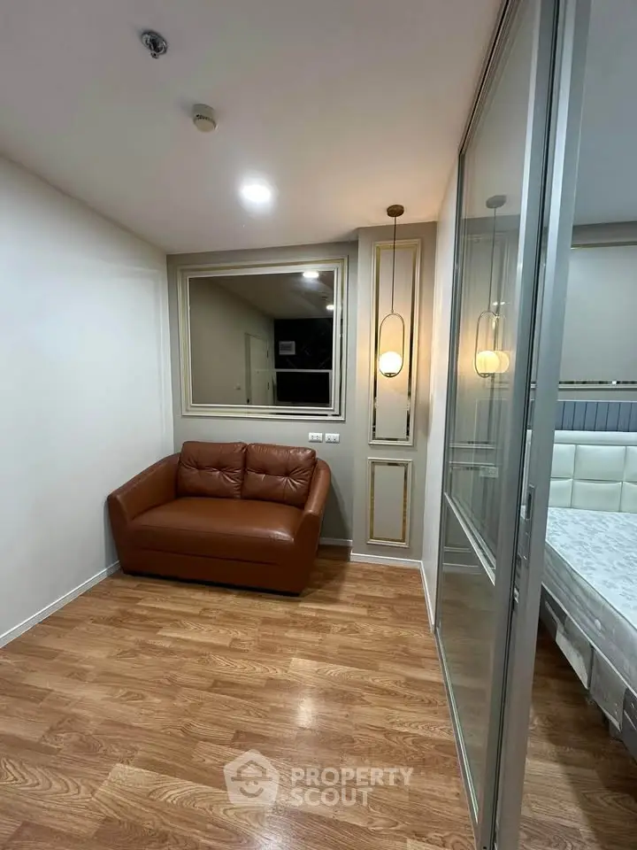 Cozy small living area with brown leather sofa and wooden flooring
