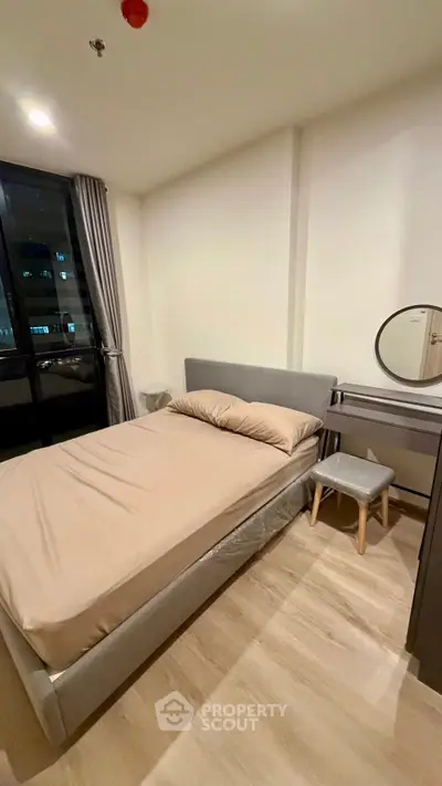 Cozy bedroom with modern furnishings and large window view