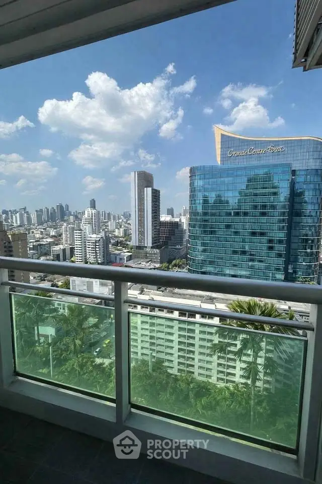 Stunning cityscape view from a high-rise balcony with modern skyline and clear blue sky.