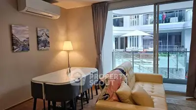 Modern living room with stylish decor and large window overlooking a courtyard.