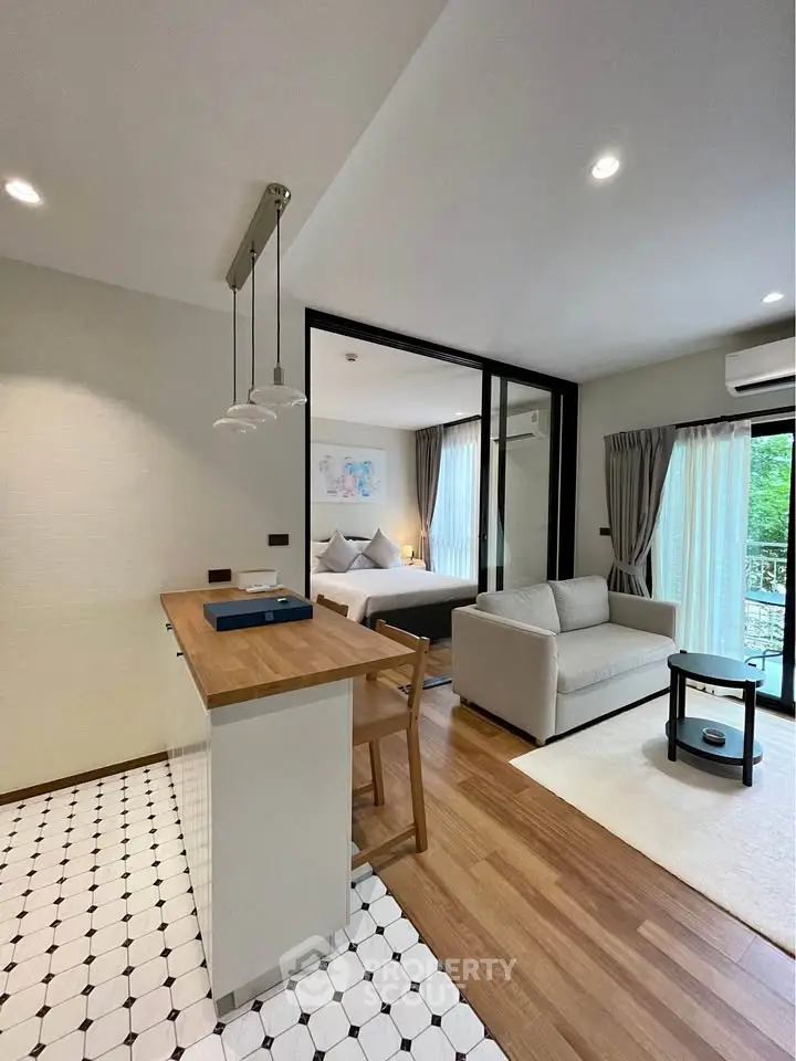 Modern open-plan living room with cozy bedroom view and stylish kitchen area.