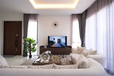 Luxurious living room with elegant decor and natural light, featuring plush sofas and a modern entertainment center.