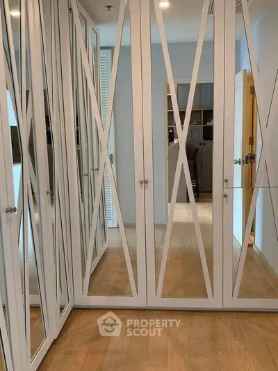 Spacious mirrored wardrobe in modern bedroom with wooden flooring