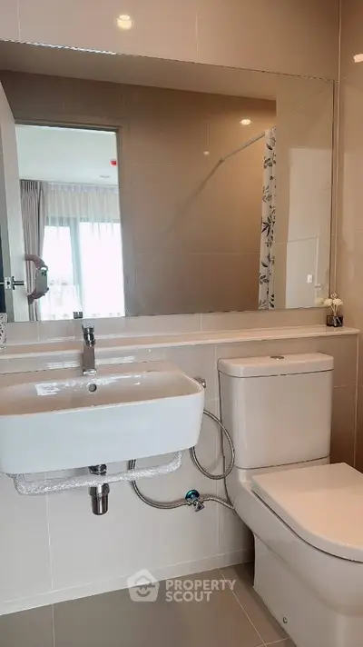 Modern bathroom with sleek fixtures and large mirror in a bright apartment.